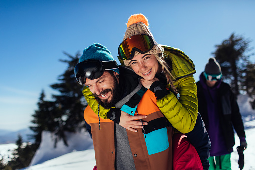 Beautiful young couple enjoying a mountain ski trip on a sunny winter day