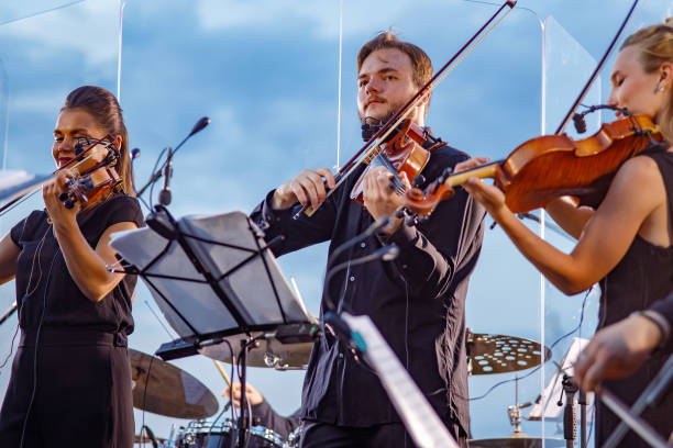 istock Musical ensemble playing violin against blue sky 1354772410