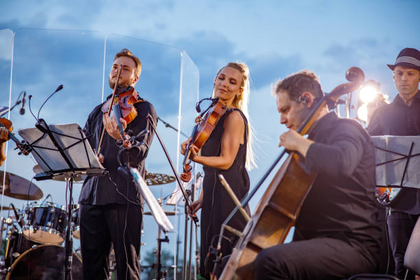 istock Musical ensemble performing orchestra concert against blue sky 1354772414
