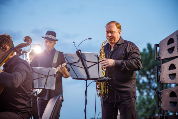 istock Saxophone player playing in orchestra on the street 1354772415