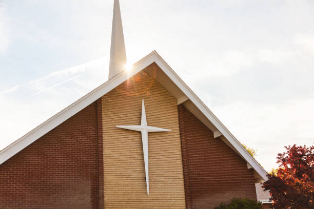 Edificio de ladrillo de la iglesia con cruz y aguja en la serie de fotos de entorno suburbano - foto de stock