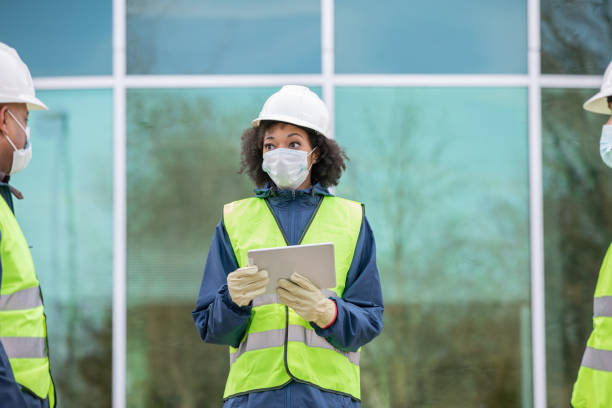 istock Engineer wears protective face mask while meeting with contractors at job site 1354774938