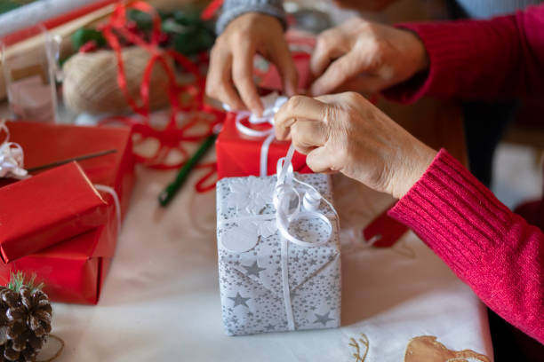 istock Hands tying Christmas bows onto gifts 1354775044