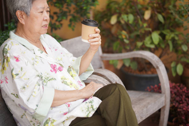 istock old elderly senior elder woman drinking hot coffee in garden 1354775572