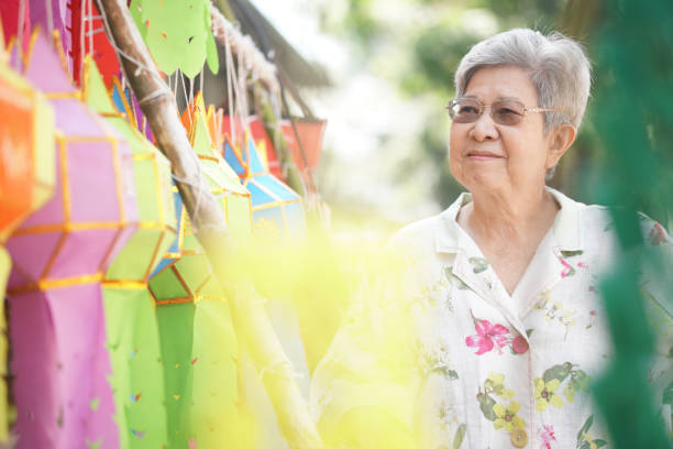 istock asian old elderly elder woman with hanging festive paper lantern 1354775579