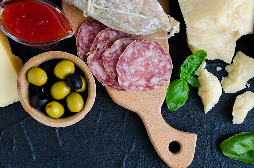 Table full of mediterranean appetizers, tapas or antipasti. Assorted Italian style banquet food set. Delicious snack on party. Chopping board with meat and cheese. Top view. Copy space.