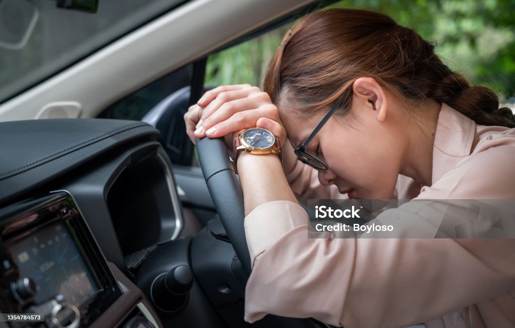 Asian woman napping in her car caused of tired from workload or feeling sleepy. If you’re feeling sleepy while driving, it is a good idea for napping in your car. Tired Stock Photo