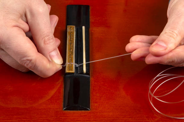 istock replacement and insertion of nylon strings in a classical guitar. lesson for a musician 1354787315