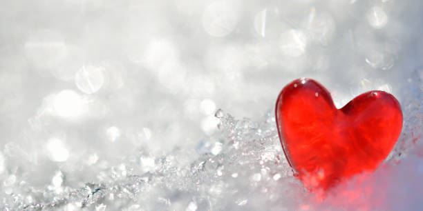 istock Red heart on shiny snow 1354791594