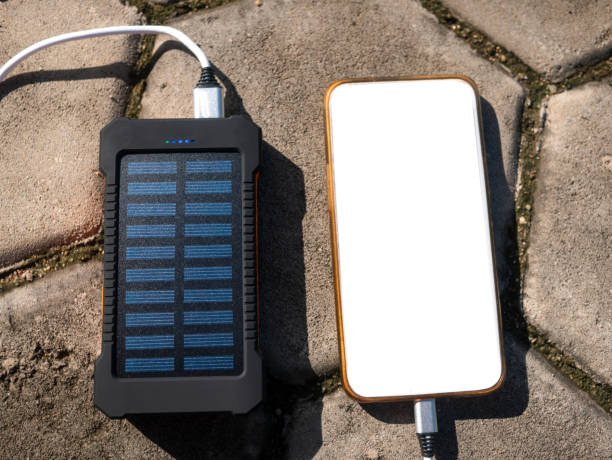 istock Rechargeable mobile power pack with solar panels, close-up. Connected to and charging a mobile, tablet or smart phone. 1354793874