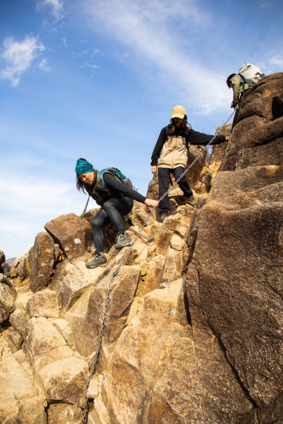 istock Female hikers descending a steep rocky mountain section 1354797800