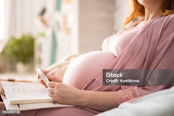 Closeup Happy Future Mother Admiring X Ray Ultrasound Photo Writing Paper Diary Relaxing On Bed Stock Photo - Download Image Now