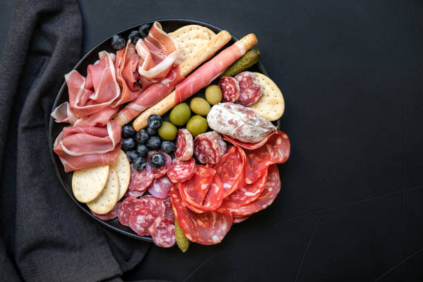 tabla de charcutería comida italiana antipasti jamón prosciutto, salami, aceitunas y palitos de pan grissini. - charcutería fotografías e imágenes de stock