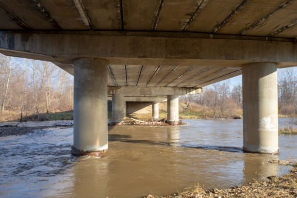 istock Concrete bridge over the river. Reinforced concrete block bridge structure, bottom view. Industrial landscape. 1354805155