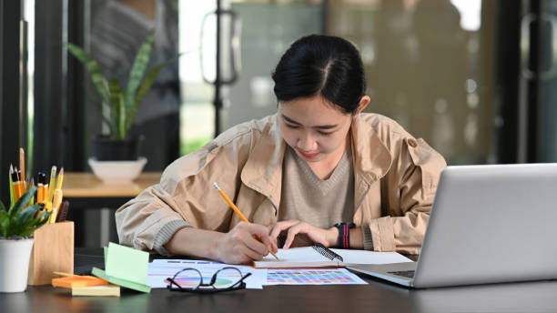 Young asian woman designer working with laptop computer in office. Young asian woman designer working with laptop computer in office. young graphic designer stock pictures, royalty-free photos & images