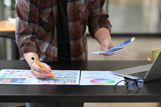 istock Young man graphic designer working with color swatches in creative office. 1354805839