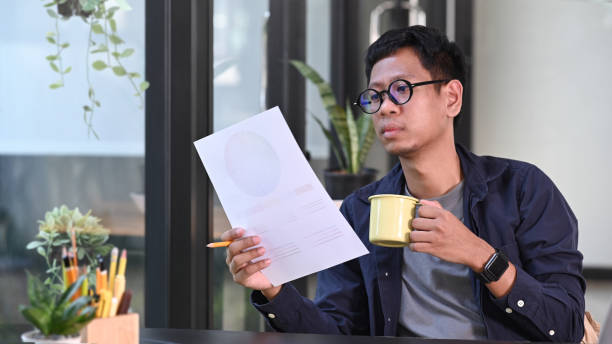 istock Asian man creative designer drinking coffee and working with color swatch in office. 1354805877