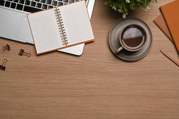 istock Top view simple workspace with computer laptop, coffee cup and notebook on wooden table. 1354805900