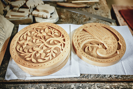 Carved wood souvenirs for sale with images of plants and birds