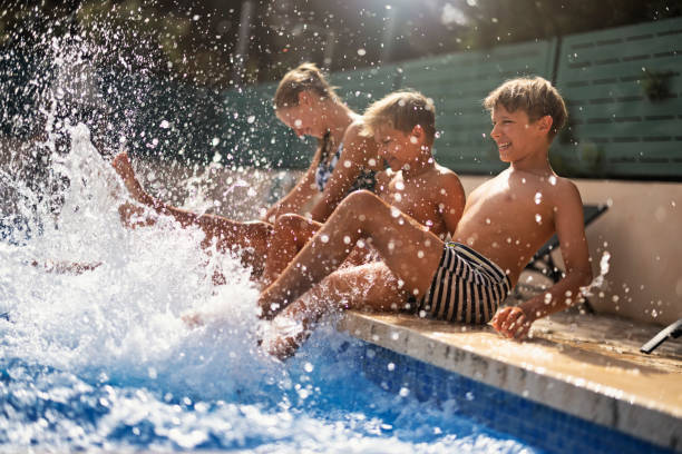 istock Kids enjoying splashing in swimming pool 1354813215
