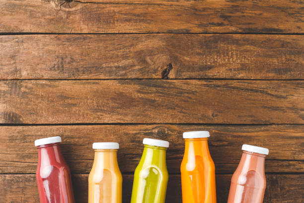 istock Fresh fruit and vegetable juices in bottles on old wooden background with copyspace 1354814112