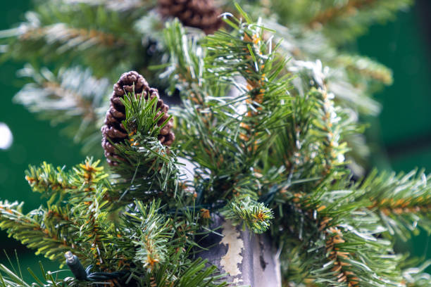 istock Evergreen branch decoration and pine cones wrapped around pole 1354814151
