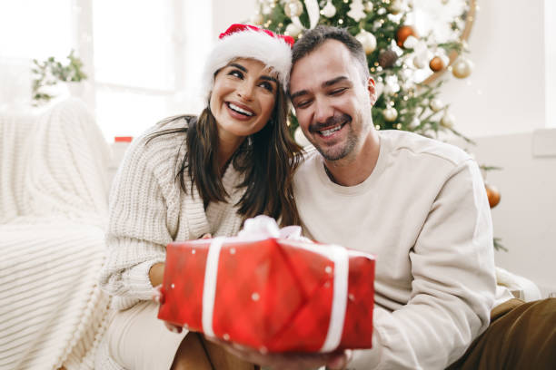 istock Young cheerful couple in love with present for Christmas 1354814928