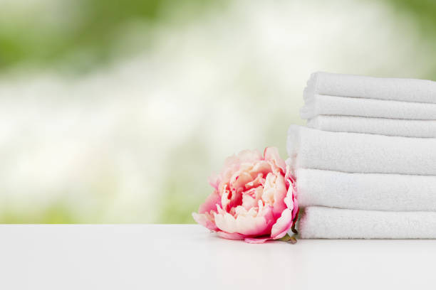 istock Towels with flowers on light table against blurred background 1354816057