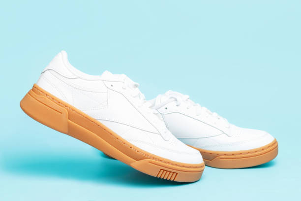 istock Levitation of white sneakers close-up on blue background. 1354817398