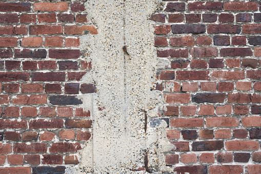 Old damaged brick wall splattered with white paint