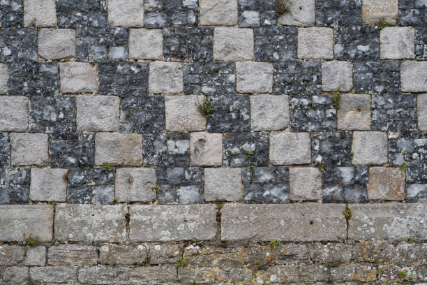 detailed closeup of a medieval stone wall with bricks in the center as decoration.