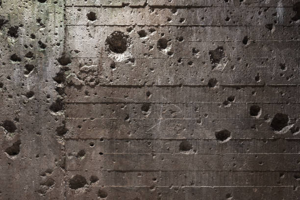 istock Texture of old bunker wall with holes from explosion 1354818155