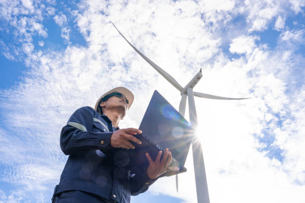 l'ingegnere cammina per controllare gli impianti eolici con controllare le prestazioni. le turbine eoliche sono una fonte di elettricità alternativa per essere risorse sostenibili in futuro. il concetto di energia pulita salva il mondo - farm scenics landscape alternative energy foto e immagini stock