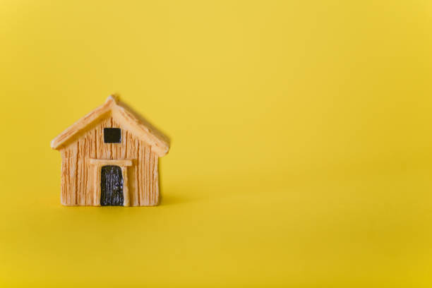 istock A small toy house on a yellow background. 1354820282
