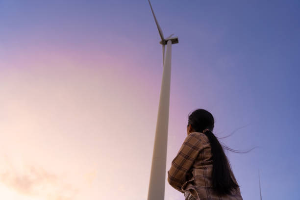 le turbine eoliche sono una fonte di elettricità alternativa per essere risorse sostenibili in futuro. persone nella comunità con generatori eolici turbine. il concetto di energia pulita salva il mondo - farm scenics landscape alternative energy foto e immagini stock