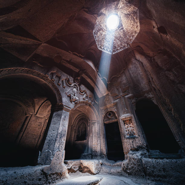 Interior of the famous Geghard Monastery and church carved into the rock. A ray of light illuminates an ancient bas-relief depicting lions in the hall Interior of the famous Geghard Monastery and church carved into the rock. A ray of light illuminates an ancient bas-relief depicting lions in the hall monastery stock pictures, royalty-free photos & images