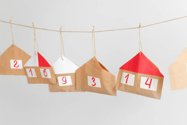 istock Advent calendar hanging on a gray one-toned wall in front. Blanks for inserting gifts for Christmas with numbers and bright colors. 1354822723