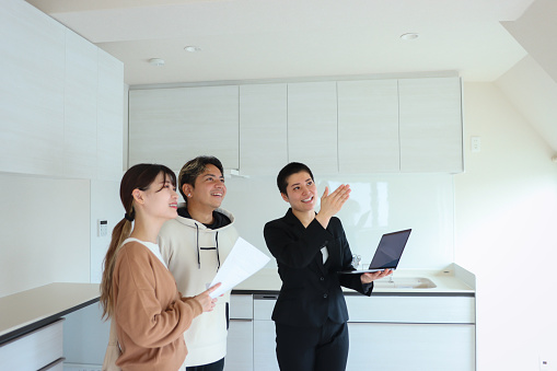 Non-Binary real estate agent and multi-ethnic young couple visit to New house