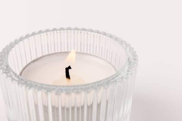 istock Burning tea candles in a glass holder, isolated on white. Space for text 1354824239