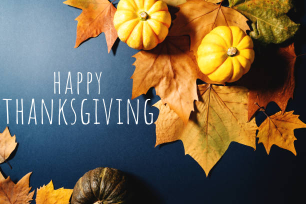 istock Happy Thanksgiving Day with maple leaves and pumpkin on blue background 1354825040