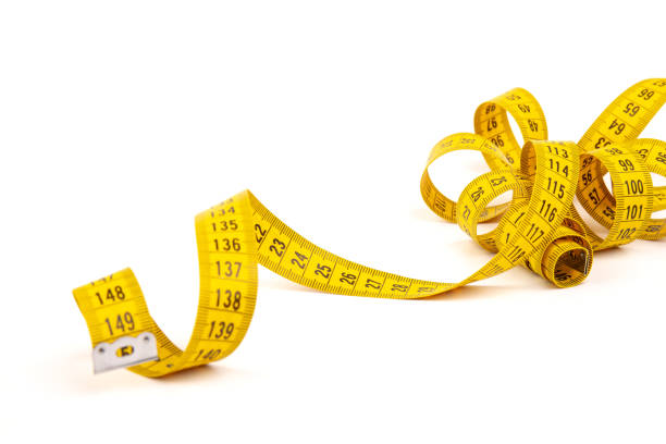 istock Yellow measuring tape spiral, isolated on white background. 1354825043