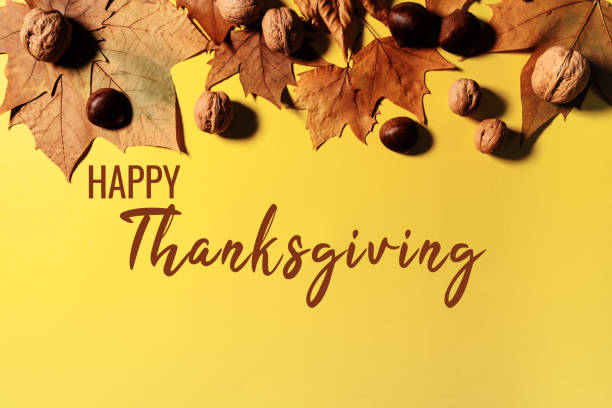 istock Happy Thanksgiving Day with maple leaves and nut on yellow background 1354825277
