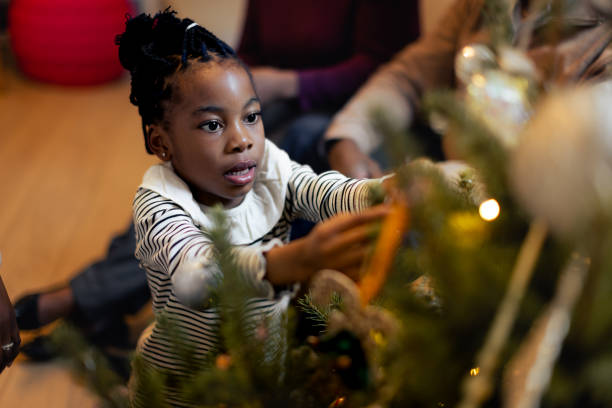istock Black girl decorating Christmas tree 1354825407