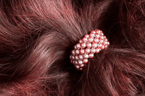 Pink pearl scrunchy on red brown hair closeup
