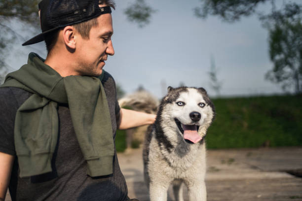 istock Adult man with his pet outdoors looking at camera 1354829297