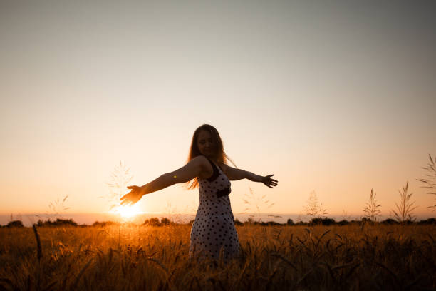 istock Woman Standing On Field Against Sky During Sunset 1354832024