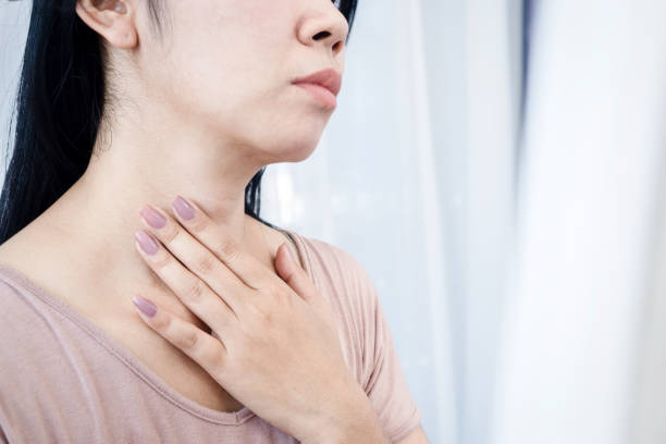closeup Asian woman having sore throat, hand touching neck feeling pain from inflammation Asian woman having sore throat, hand touching neck feeling pain from inflammation thyroid disease stock pictures, royalty-free photos & images
