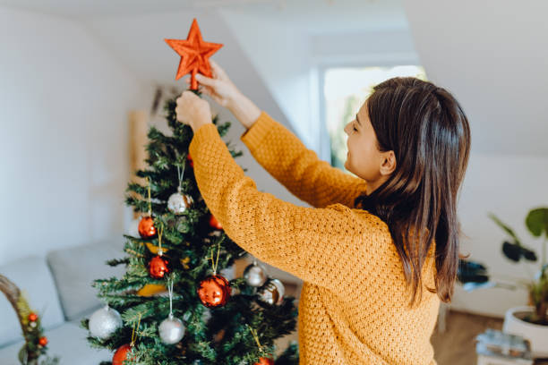istock young women decorating her home for christmas 1354834735