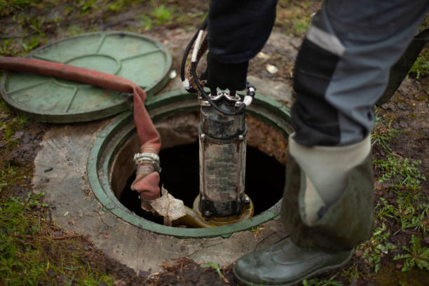 Sewer repair. The worker lowers the equipment into the sewer hatch. stock photo