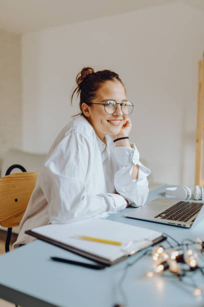 Happy young Woman in her Home Office and Using her Laptop stock photo